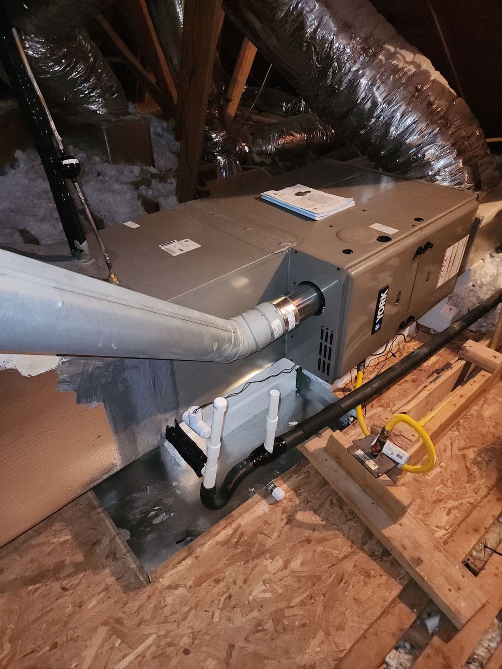 New HVAC system installed in attic with ductwork and insulation visible.